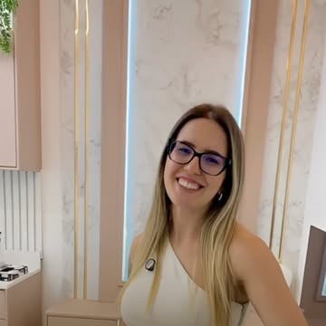 Recepção da Corpo & Laser: mármore claro, ripado dourado e mobiliário em tom nude
