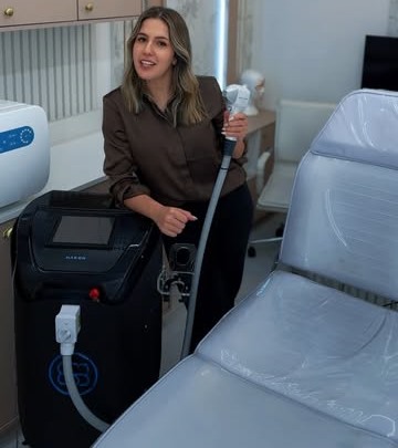 Profissional da Corpo & Laser ao lado do equipamento de depilação a laser, na sala de atendimento da clínica